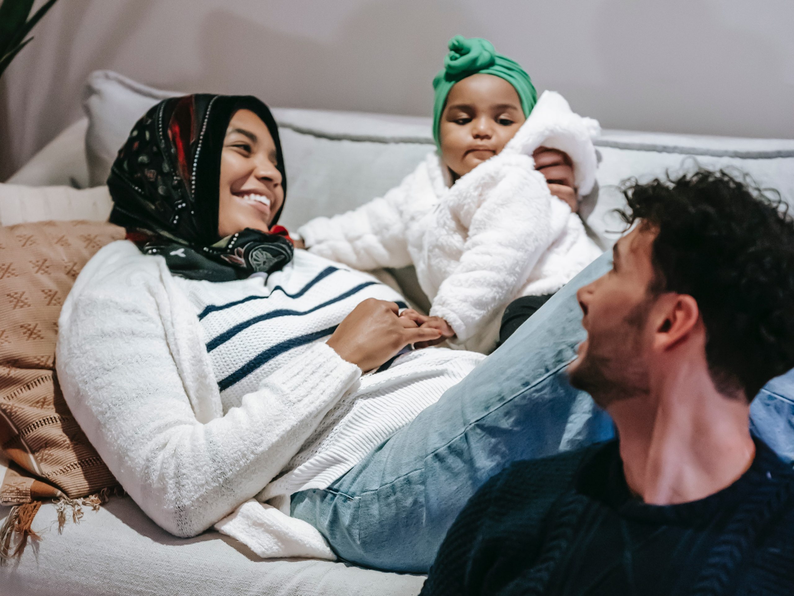child with parents relaxing on couch