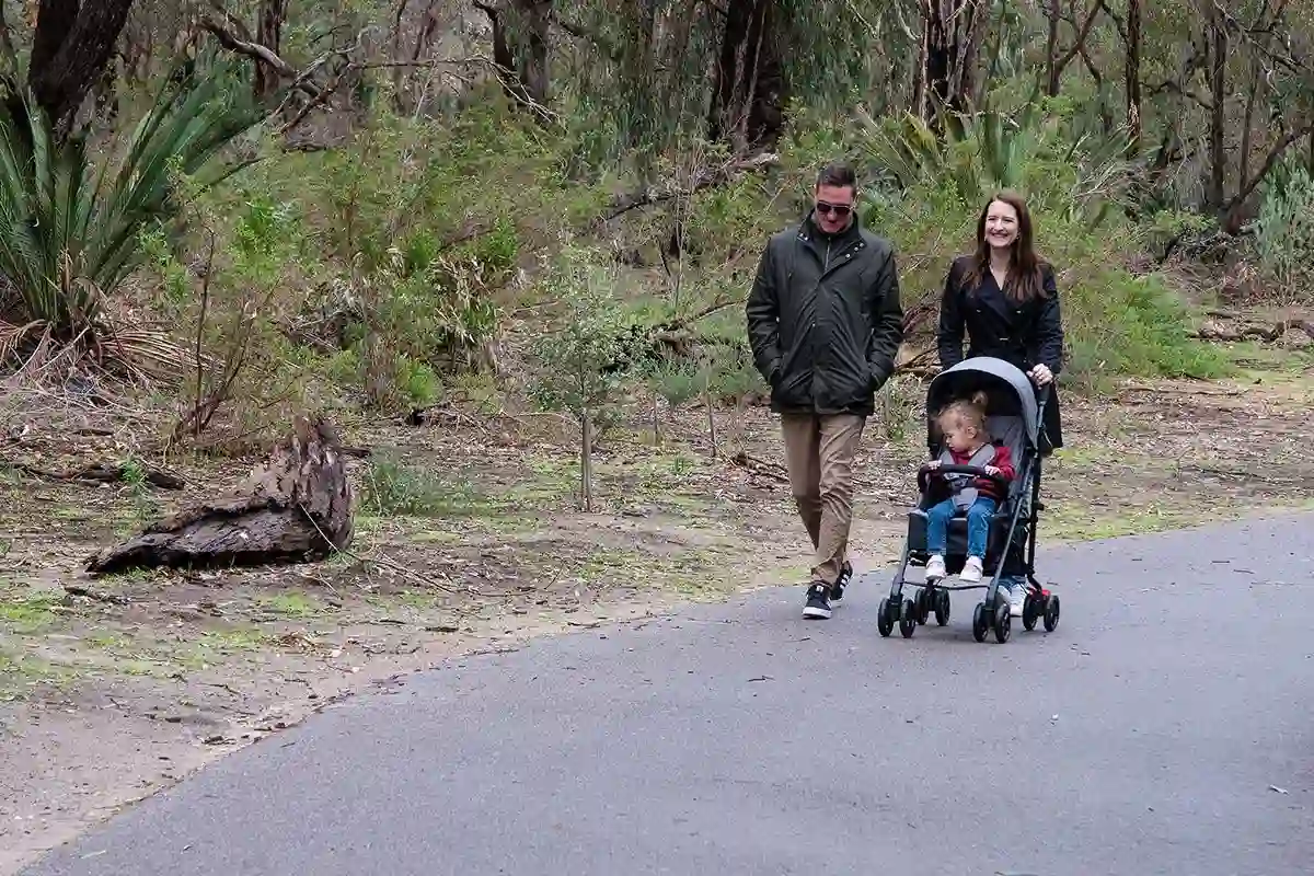 family walking on bushland path with stroller